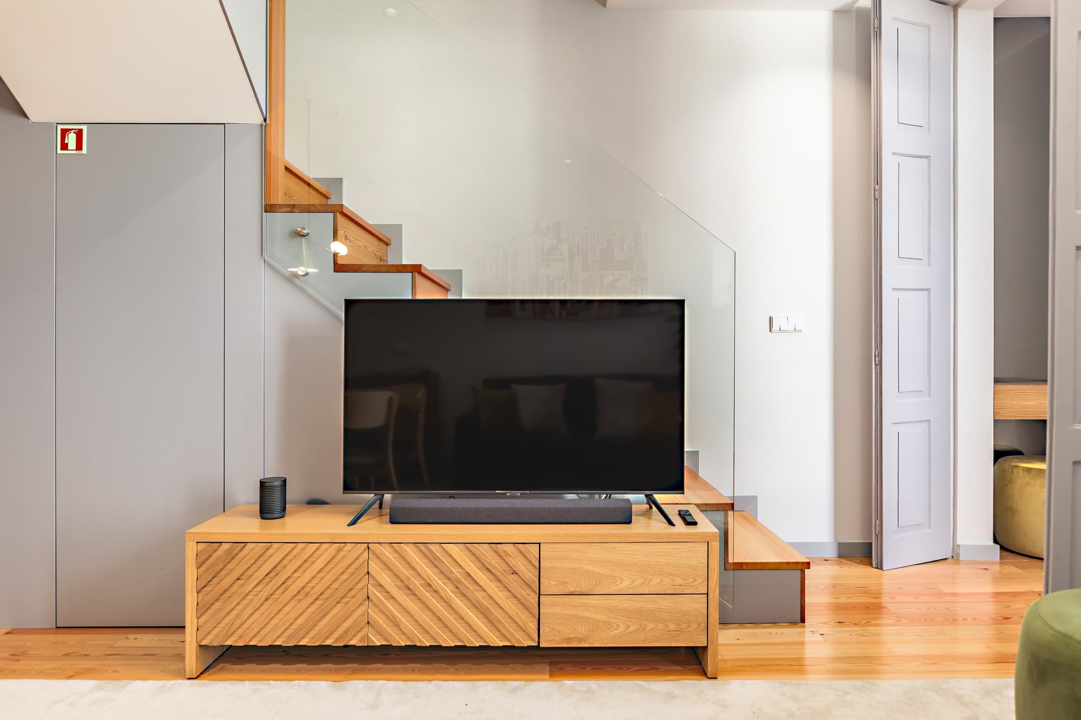 Sala do Almada 505 com televisão e escadas interiores.